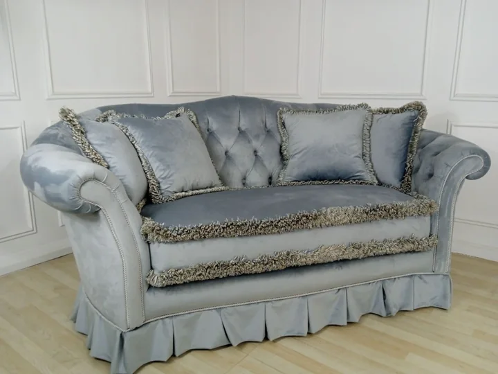 Szara sofa z frędzlami i poduszkami